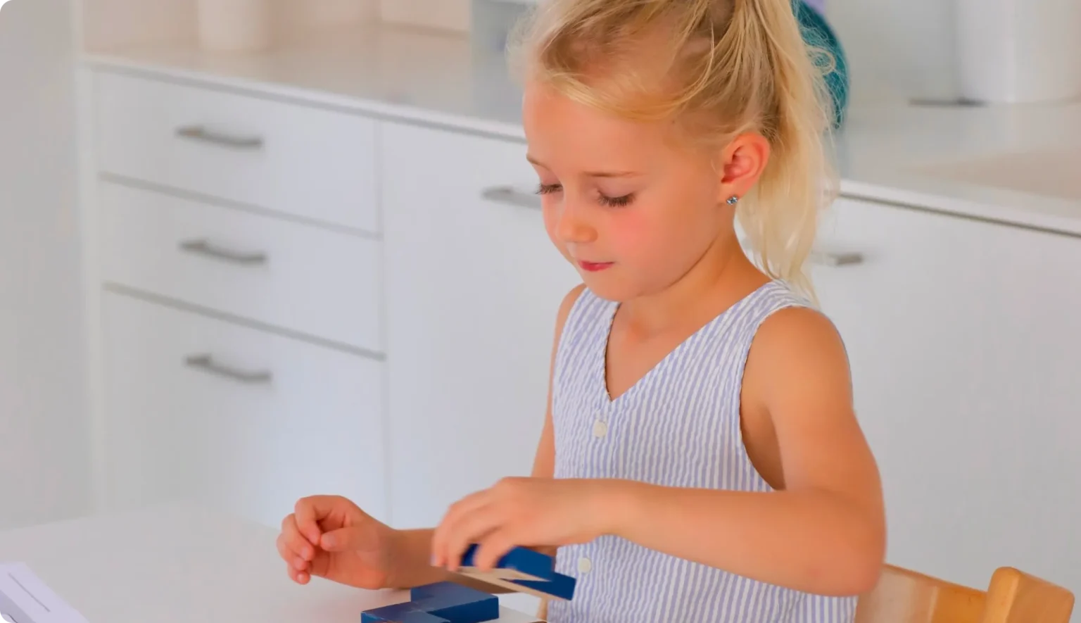 Mädchen spielt mit blauen Holzbausteinen