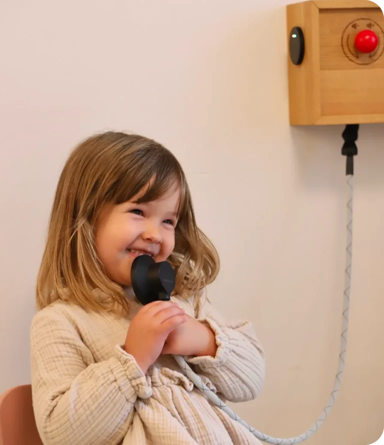 Lachendes Mädchen hört im Wartezimmer an der Hörbox